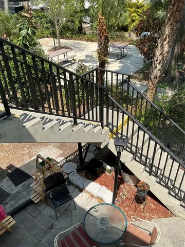 a view of a patio with table and chairs with wooden floor and fence