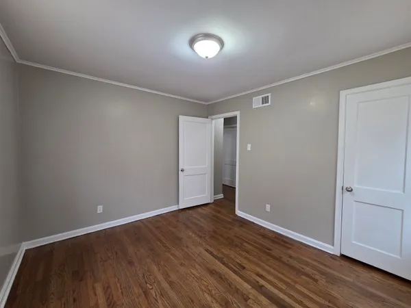 a view of an empty room with wooden floor