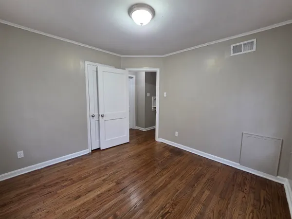 a view of an empty room with wooden floor