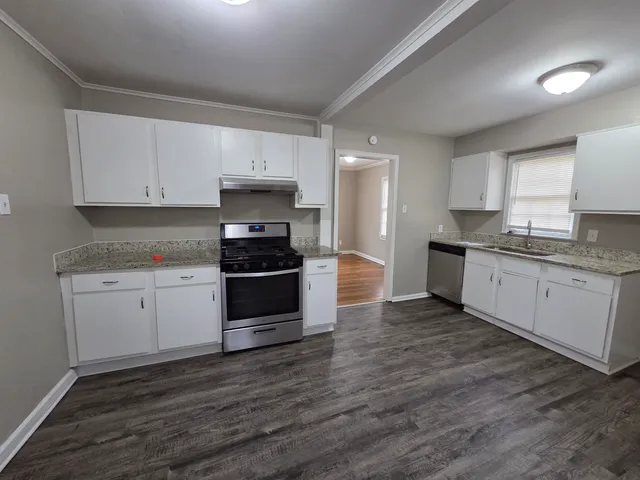 a kitchen with granite countertop white cabinets and white appliances