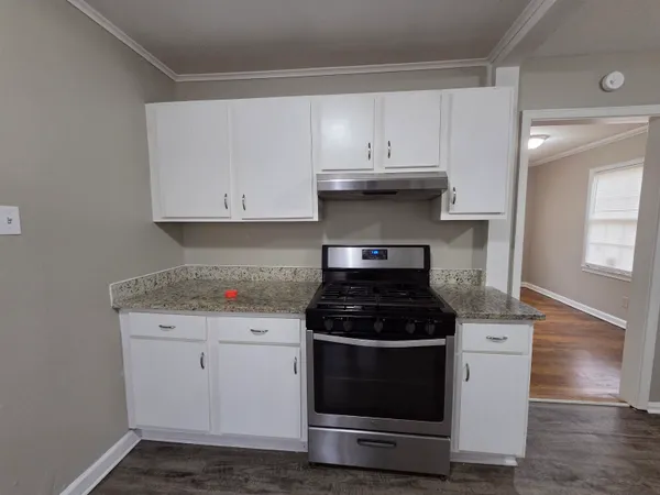a kitchen with a stove and white cabinets