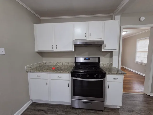 a kitchen with a stove and white cabinets