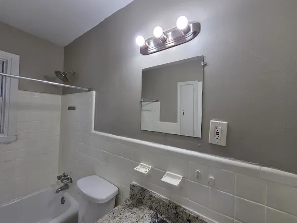 a bathroom with a sink a toilet and a mirror