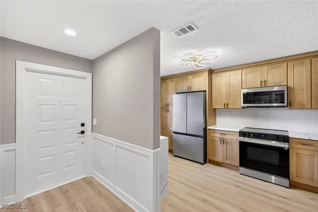 a kitchen with cabinets and stainless steel appliances