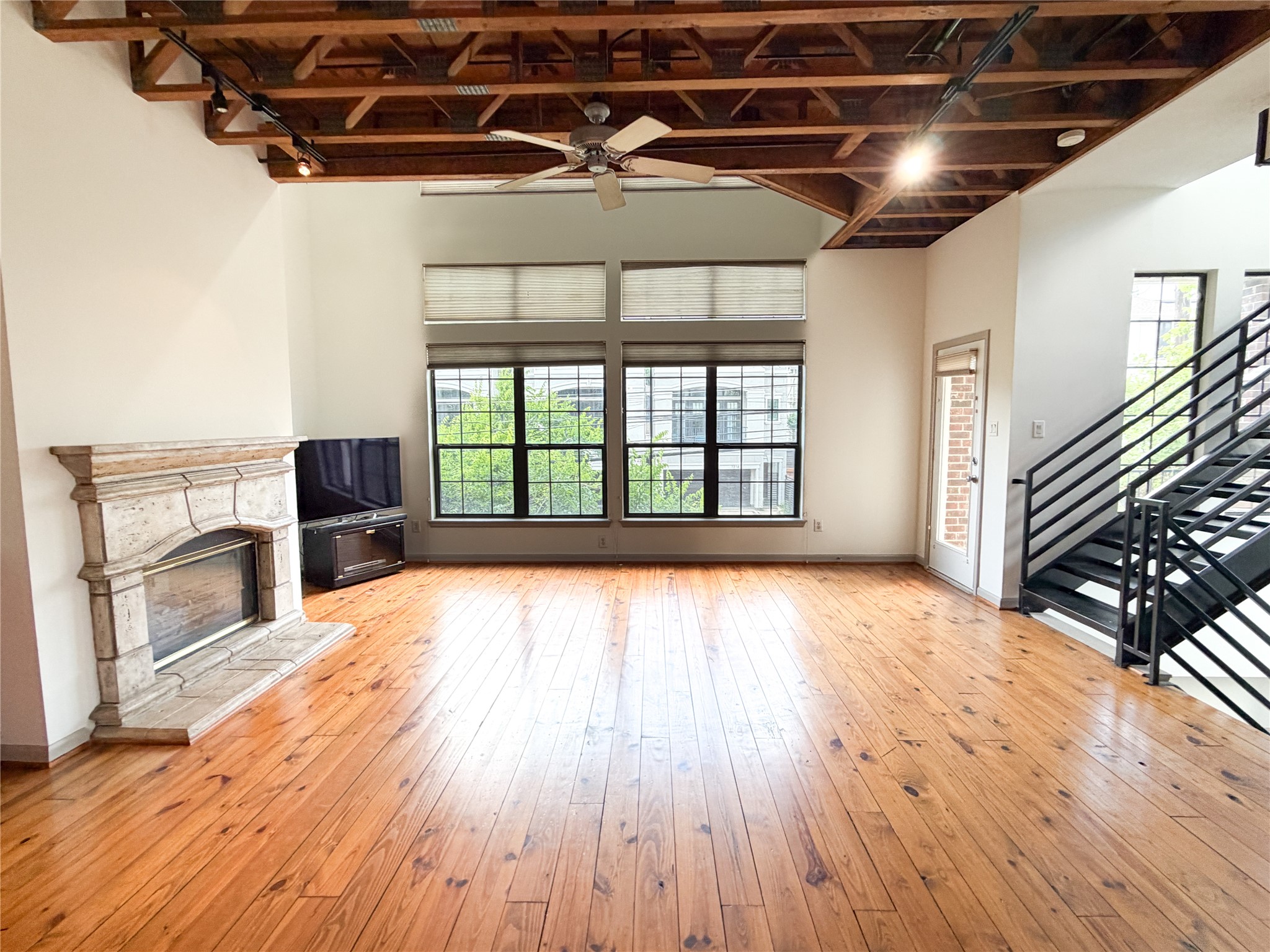 1213 Dunlavy Street Houston, TX 77019 - Photo 16 of 27 a view of an empty room with wooden floor fireplace and a window