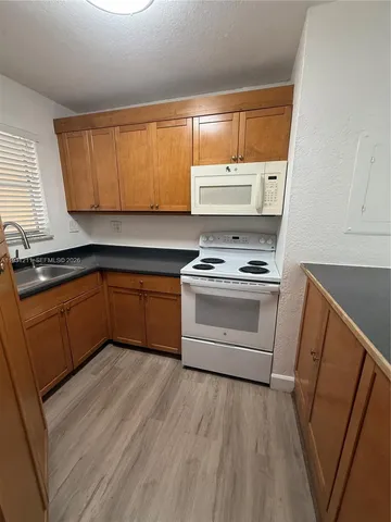 a kitchen with a sink a window and cabinets