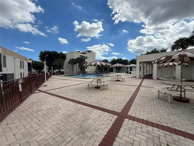 a view of a patio with dining table and chairs with wooden floor