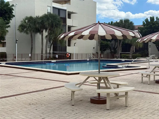a view of a chairs and table in the patio with a swimming pool