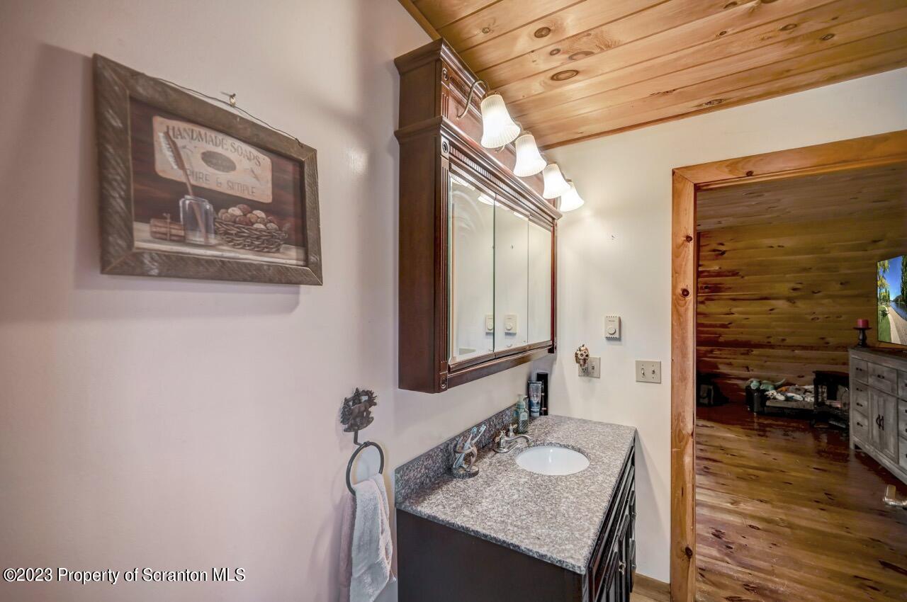 6733 State Rte 2012 Union Dale, PA 18470 - Photo 54 of 69 a bathroom with a granite countertop sink and a mirror
