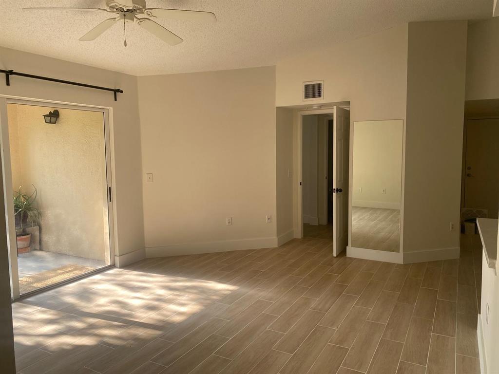 2457 Centergate Drive, Unit 302 Miramar, FL 33025 - Photo 3 of 10 an empty room with wooden floor and a ceiling fan