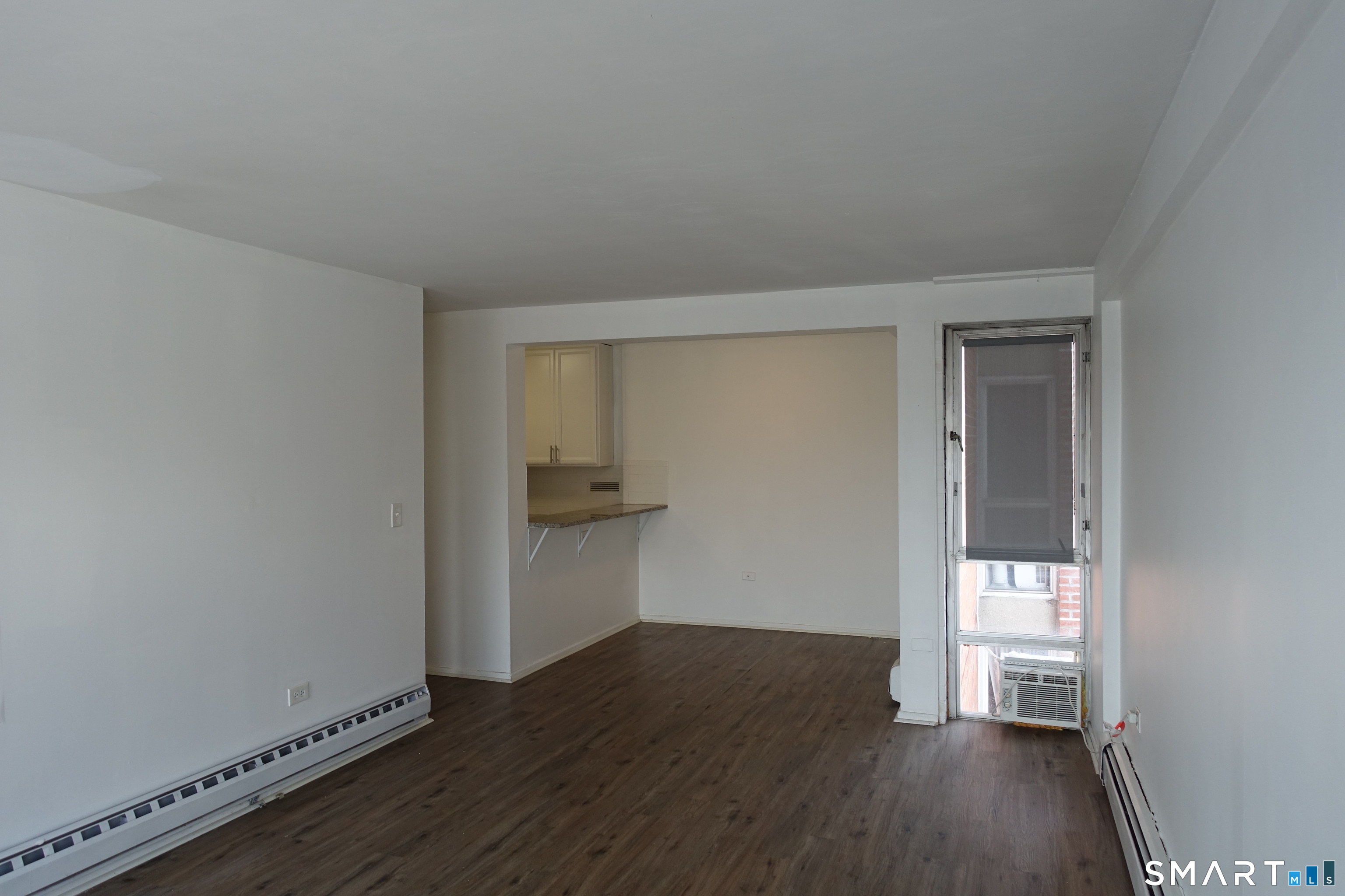 87 Glenbrook Road, Unit 6E Stamford, CT 06902 - Photo 2 of 23 a view of an empty room with wooden floor and a window