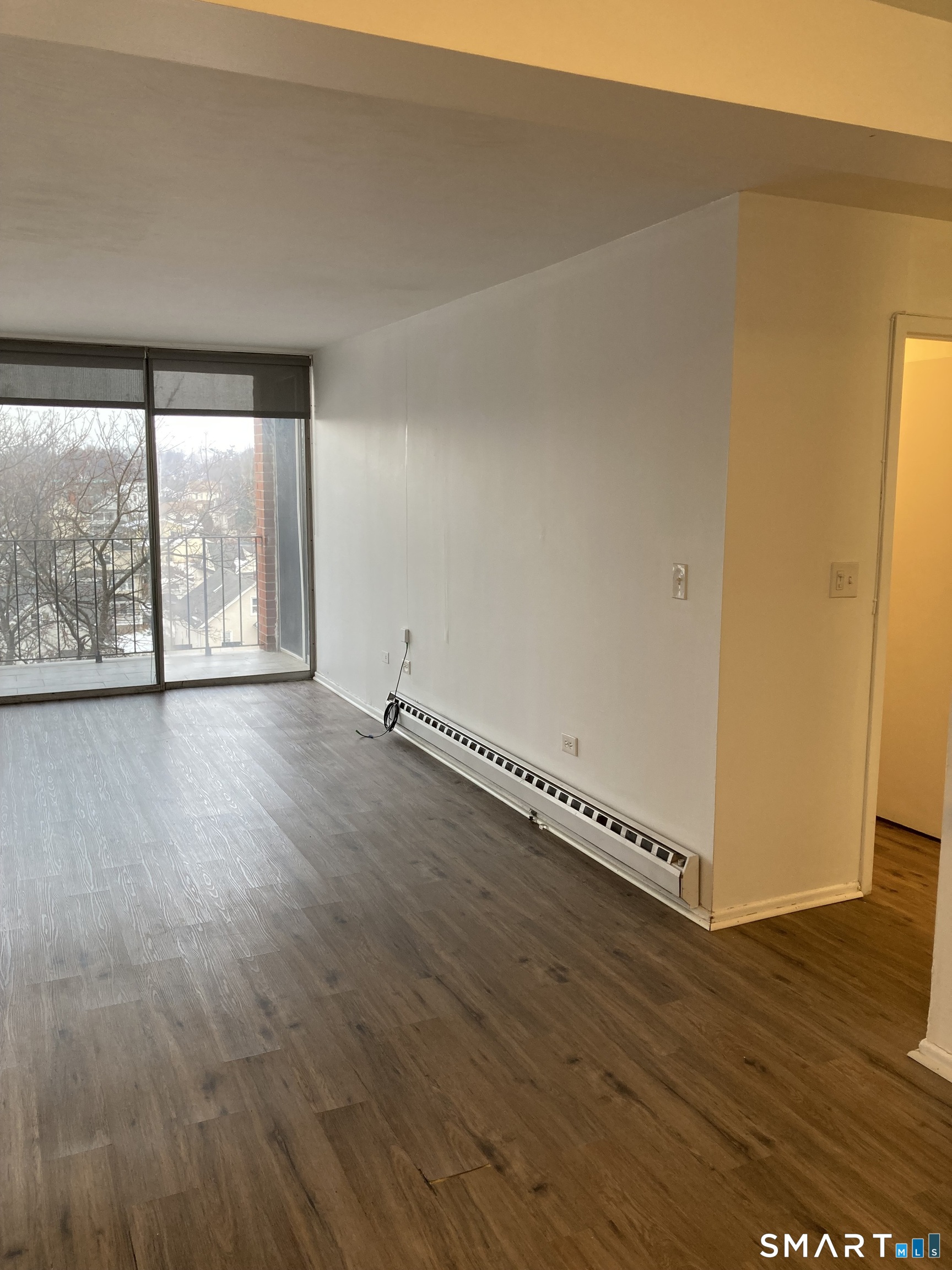 87 Glenbrook Road, Unit 6E Stamford, CT 06902 - Photo 23 of 23 a view of an empty room with wooden floor and a window
