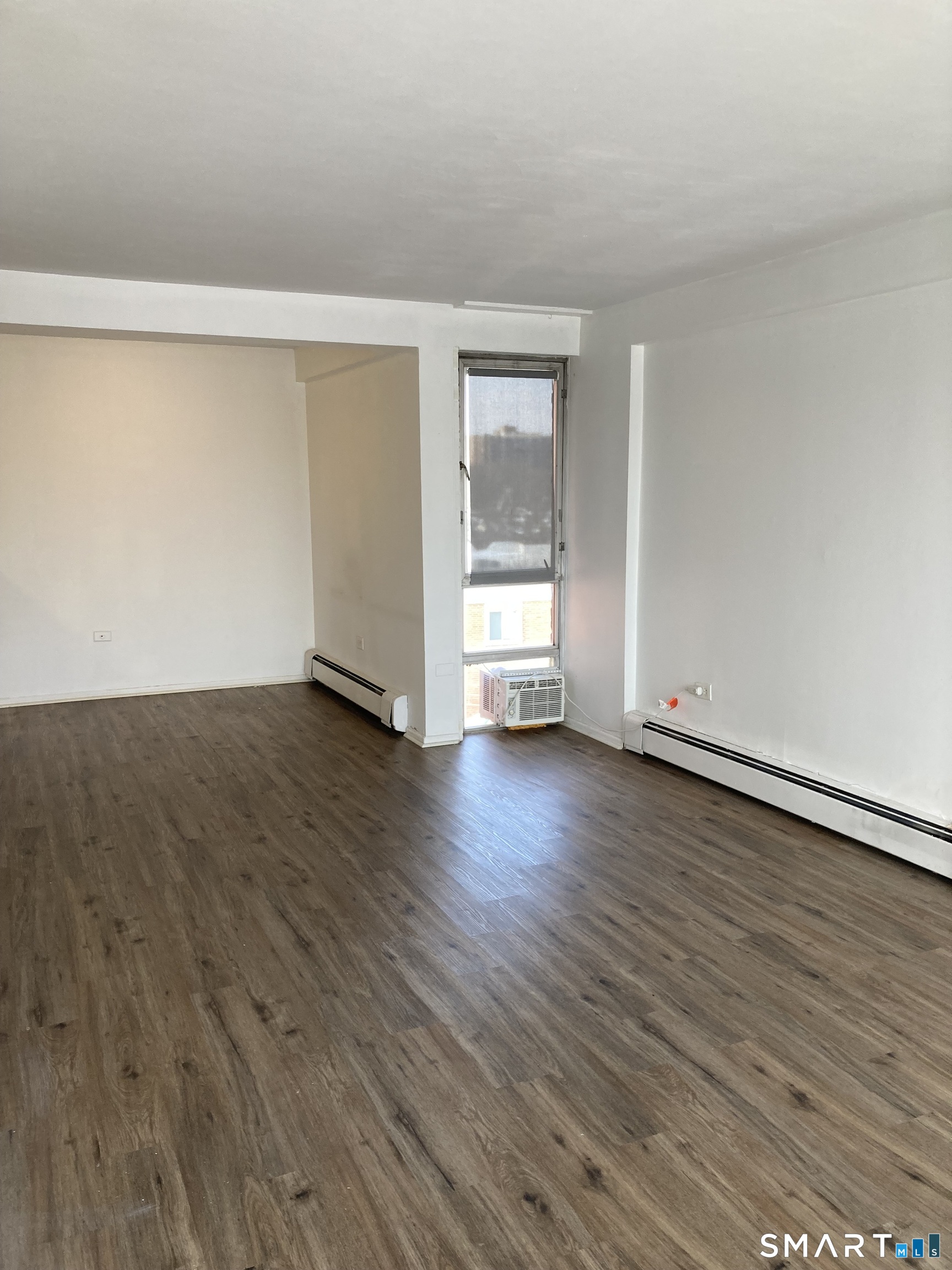 87 Glenbrook Road, Unit 6E Stamford, CT 06902 - Photo 3 of 23 a view of empty room with wooden floor and fan