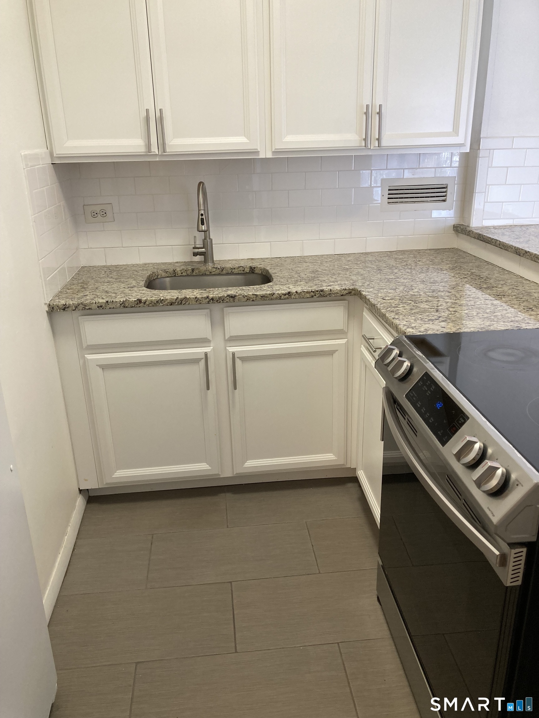 87 Glenbrook Road, Unit 6E Stamford, CT 06902 - Photo 4 of 23 a kitchen with granite countertop white cabinets and a stove