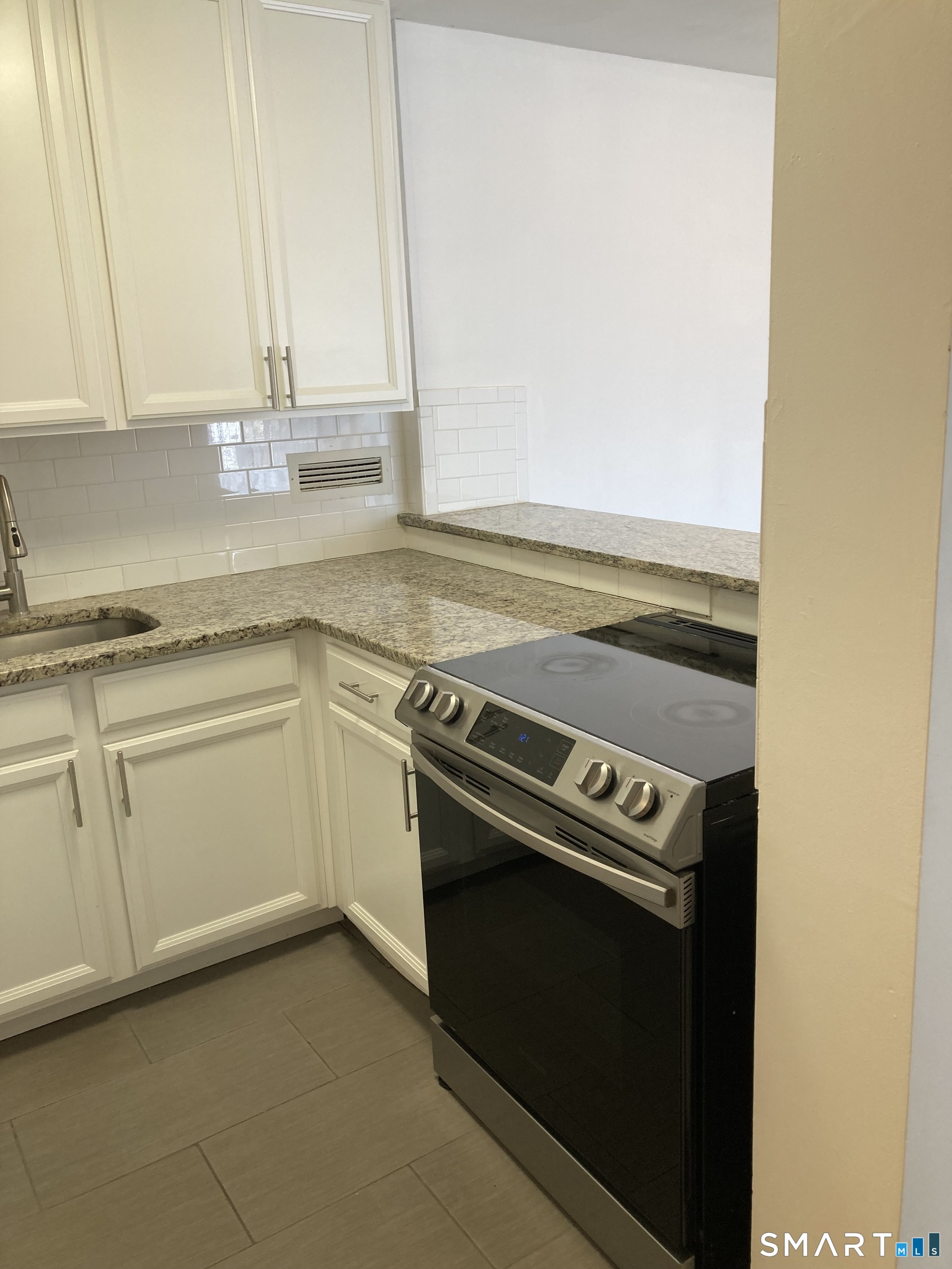 87 Glenbrook Road, Unit 6E Stamford, CT 06902 - Photo 5 of 23 a kitchen with granite countertop white cabinets and white appliances
