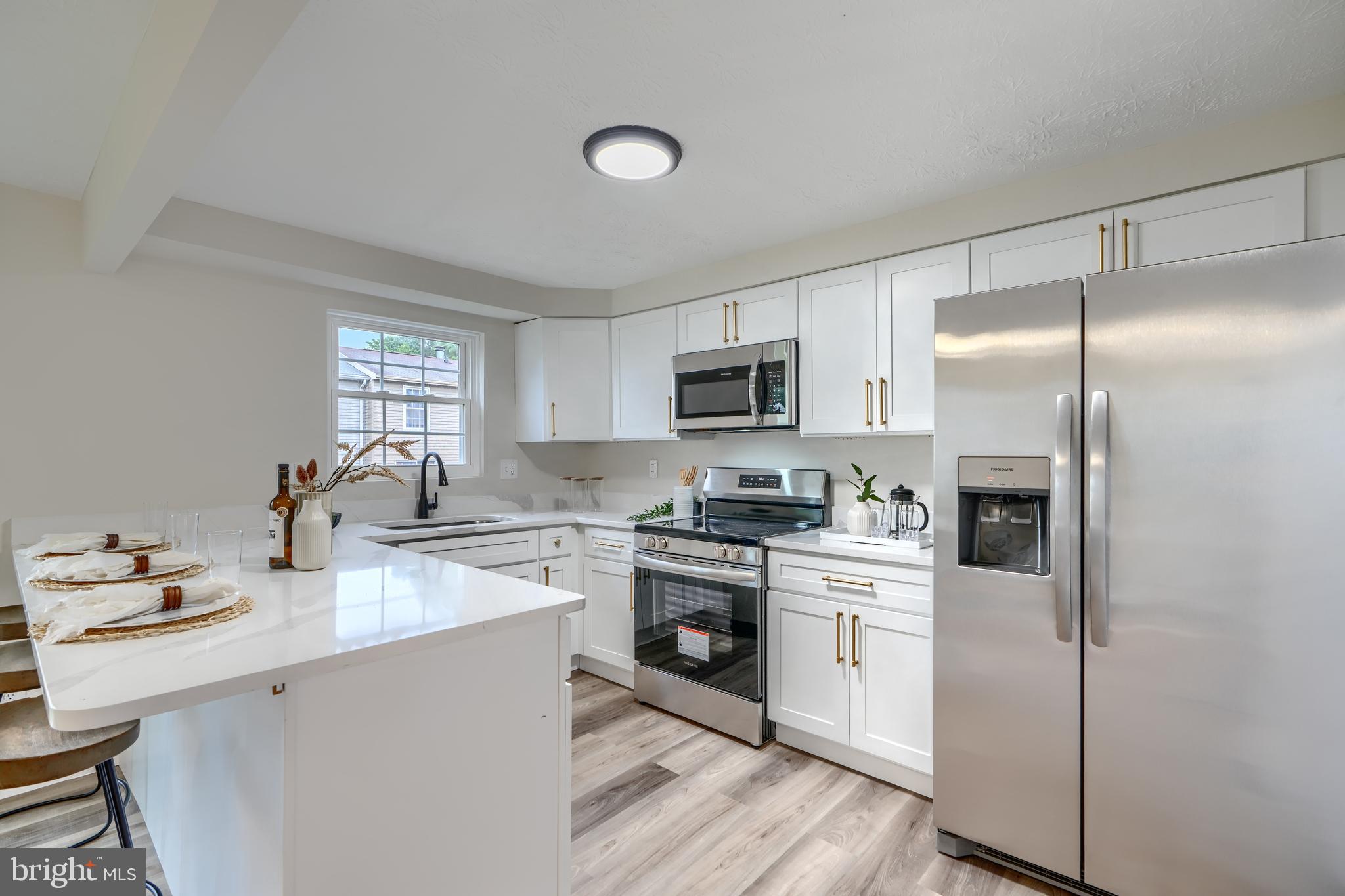 4008 Rustico Road Baltimore, MD 21220 - Photo 13 of 37 a kitchen with a sink stainless steel appliances and white cabinets