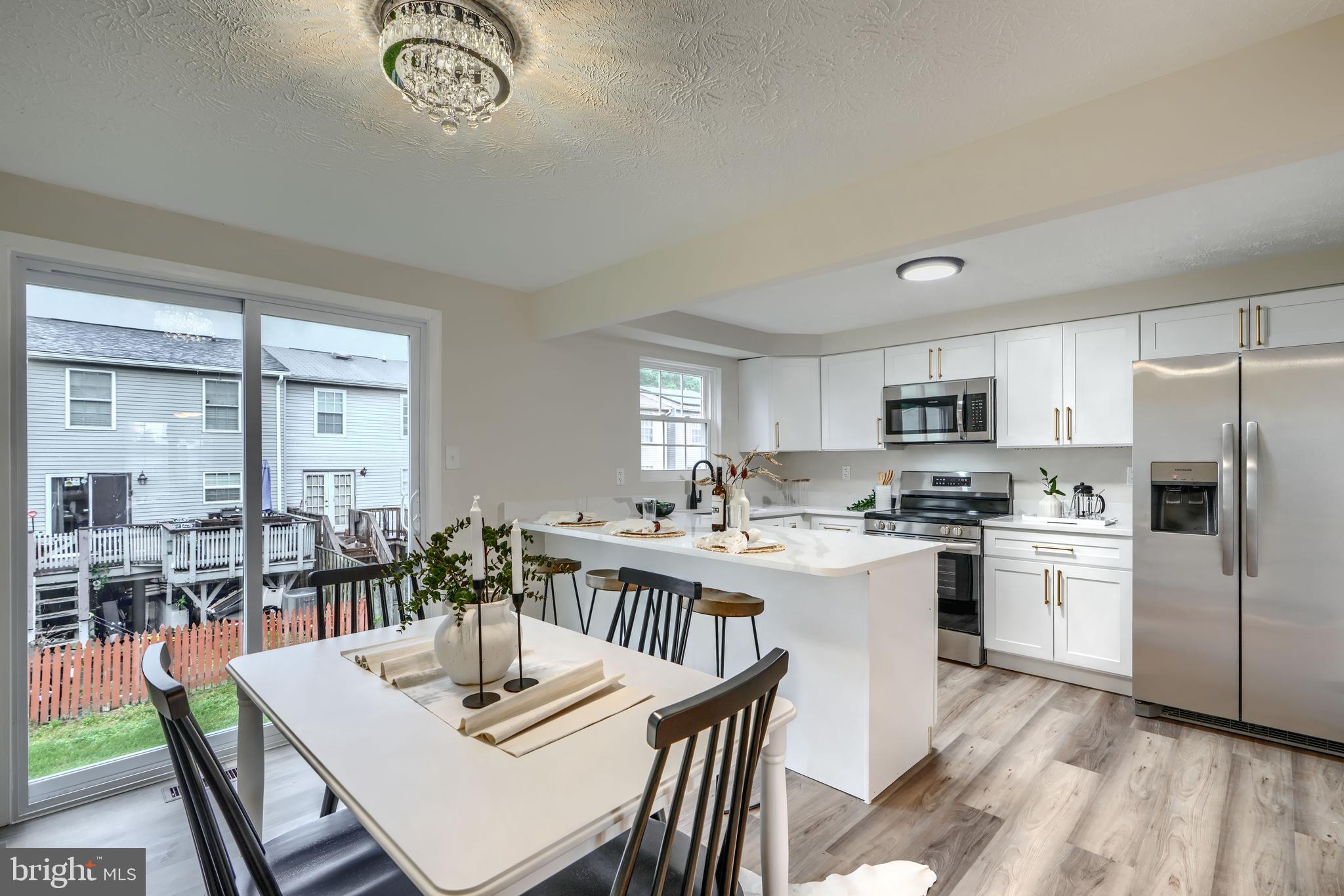 4008 Rustico Road Baltimore, MD 21220 - Photo 7 of 37 a kitchen with stainless steel appliances kitchen island granite countertop a stove a sink a dining table and chairs