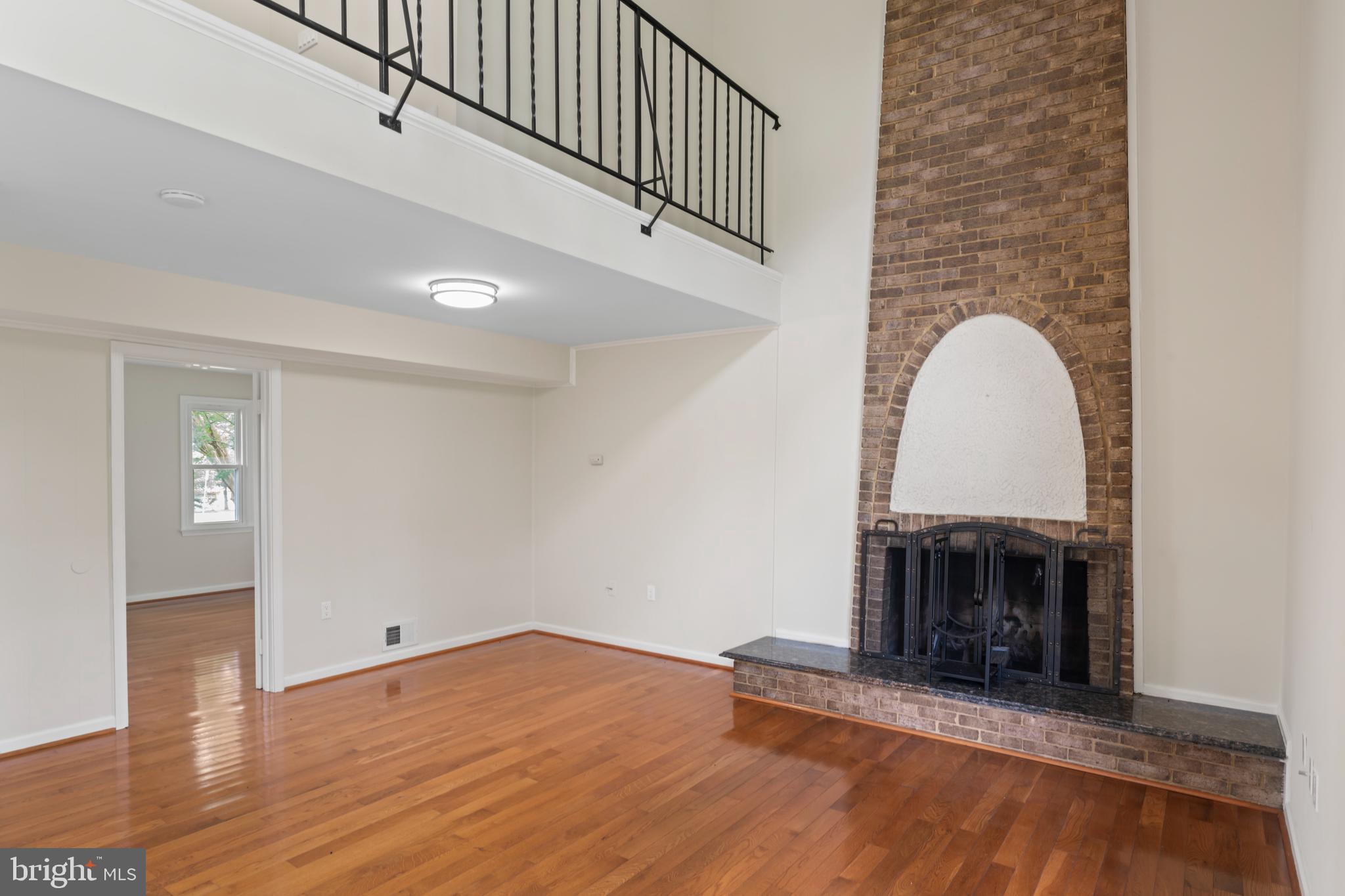 17004 Cashell Road Rockville, MD 20853 - Photo 23 of 80 a view of an empty room with wooden floor fireplace and a window