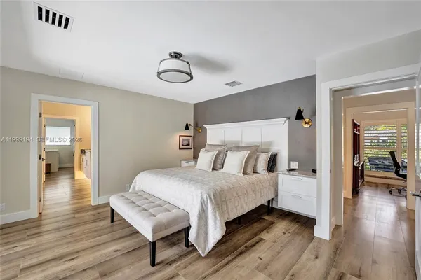 a bedroom with a bed and wooden floor