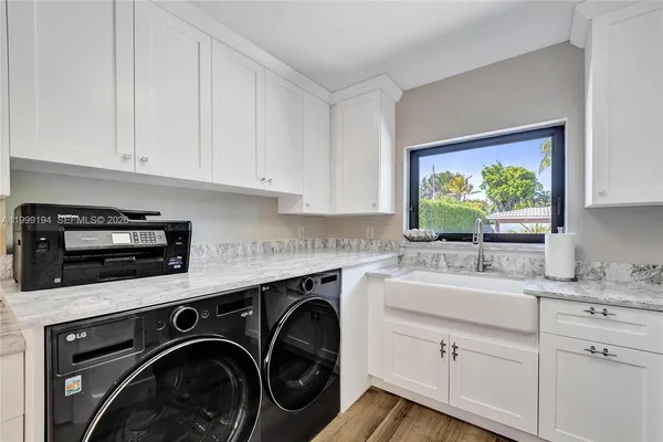 a kitchen with stainless steel appliances white cabinets sink and window