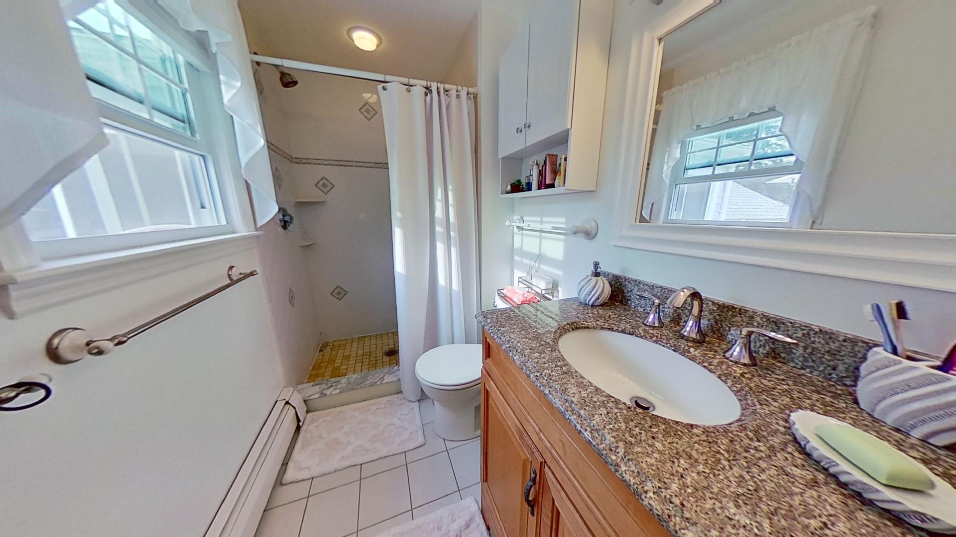 29 Padlock Lane Centerville, MA 02632 - Photo 15 of 33 a bathroom with a granite countertop sink a mirror a toilet and a shower