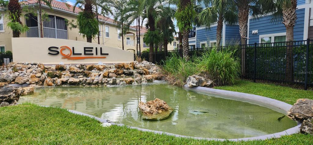 8220 Enclave Way, Unit 101 Sarasota, FL 34243 - Photo 2 of 8 a view of a lake with a house and a yard
