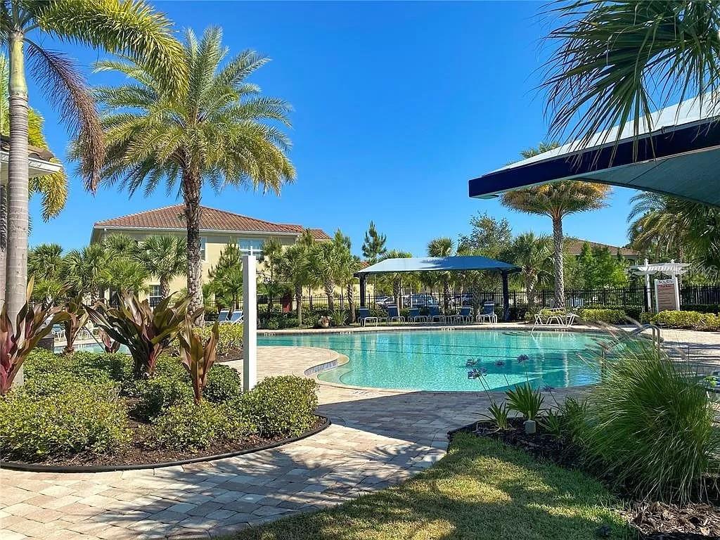 8220 Enclave Way, Unit 101 Sarasota, FL 34243 - Photo 4 of 8 a view of a backyard with a garden and swimming pool