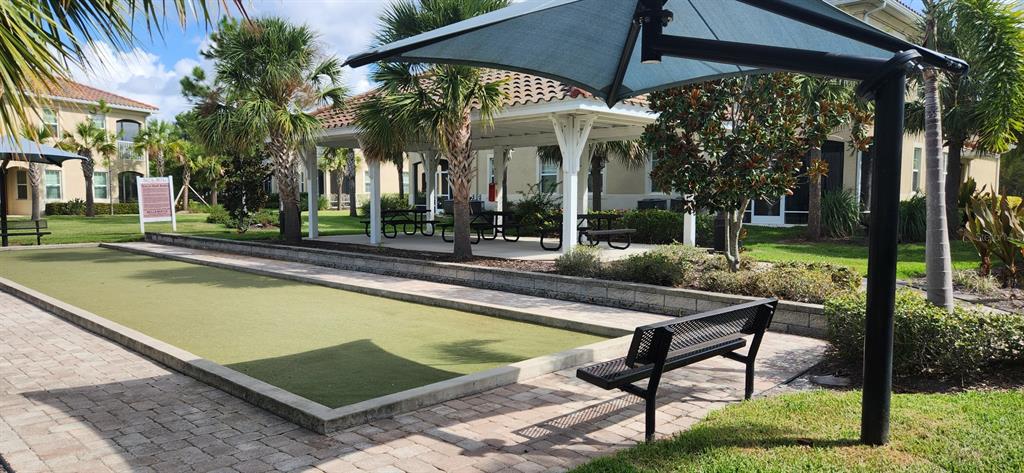 8220 Enclave Way, Unit 101 Sarasota, FL 34243 - Photo 7 of 8 a view of a patio with chairs and table under an umbrella