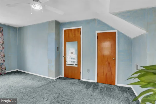 an empty room with closet and a chandelier fan