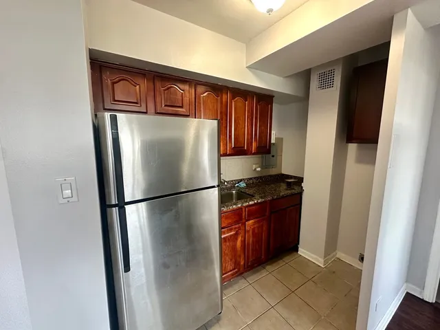 a kitchen with stainless steel appliances granite countertop a refrigerator and a stove