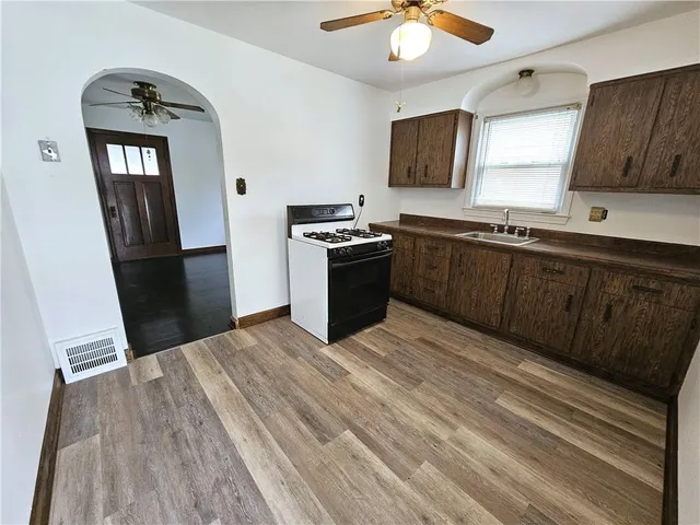 a kitchen with granite countertop a refrigerator stove and sink