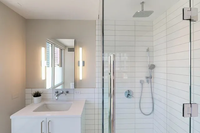 a bathroom with a shower sink and mirror