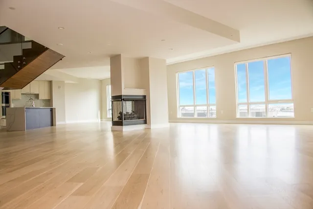 a view of empty room with wooden floor and fireplace