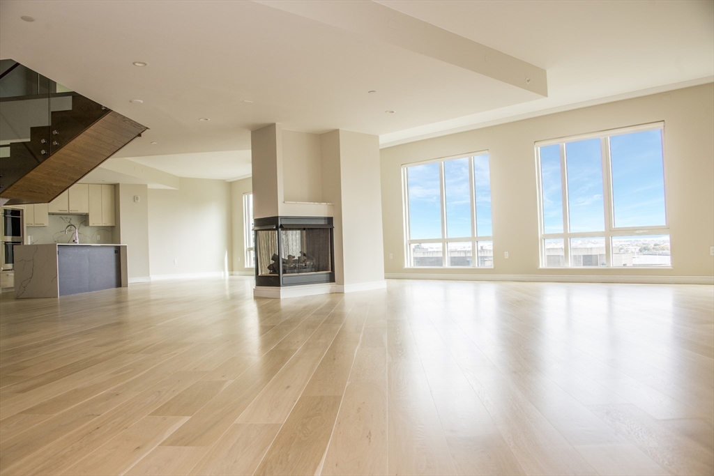 110 Broad Street, Unit 1102 Boston, MA 02110 - Photo 9 of 26 a view of empty room with wooden floor and fireplace