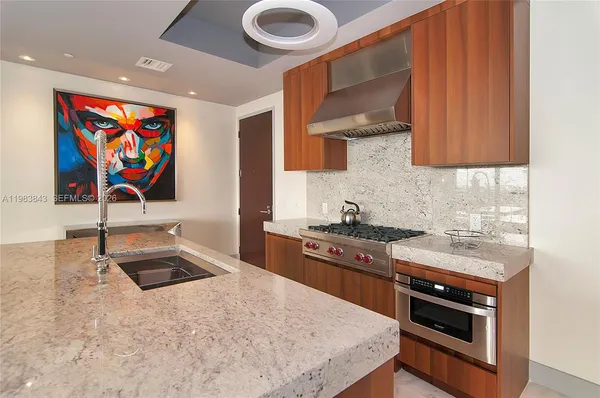 a kitchen with stainless steel appliances granite countertop a stove and a sink