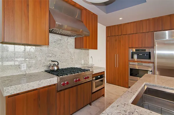 a kitchen with stainless steel appliances granite countertop a sink stove and refrigerator