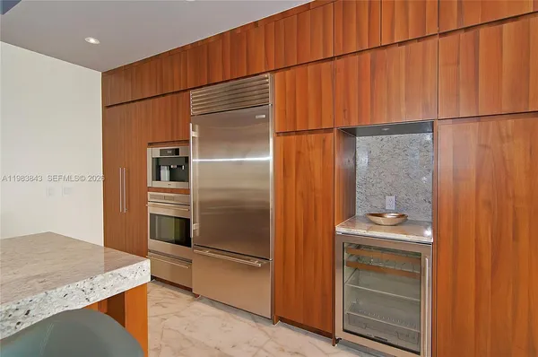 a kitchen with stainless steel appliances granite countertop a refrigerator and a sink