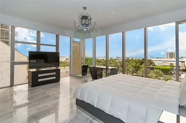 a bedroom with a bed and large window with balcony view