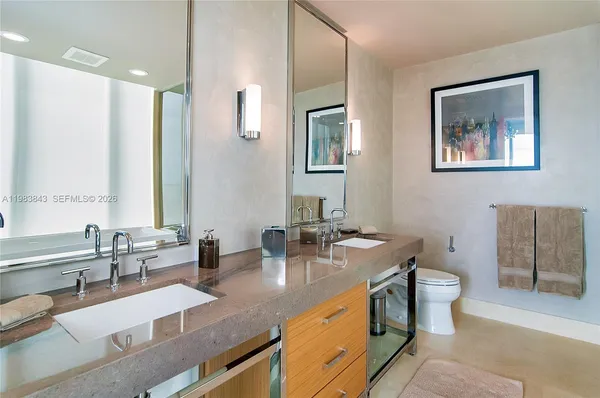 a bathroom with a granite countertop sink mirror and toilet