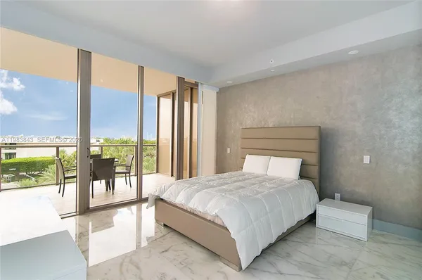 a bedroom with a large bed and a large window