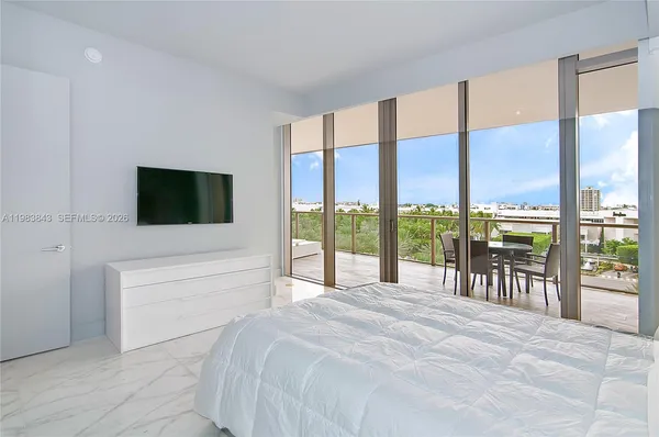 a spacious bedroom with a large window and a bed