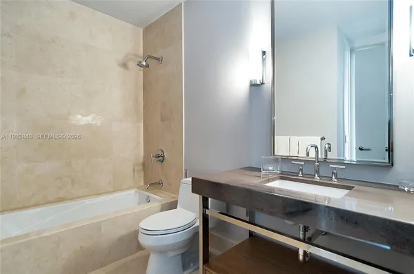 a bathroom with a sink a toilet a mirror and shower