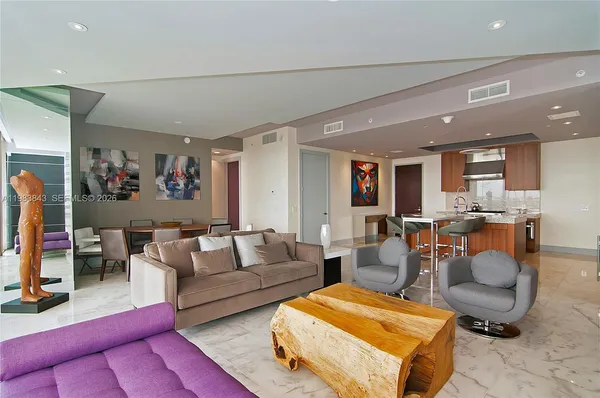 a living room with furniture and a view of kitchen