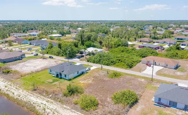 an aerial view of a house with a yard and lake view in back