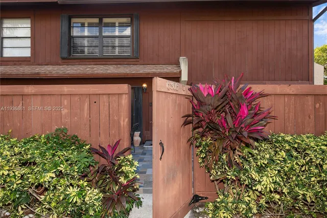 a vase with flowers sitting on a wooden floor