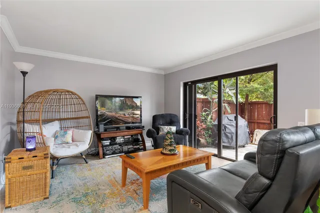 a living room with furniture a window and a flat screen tv