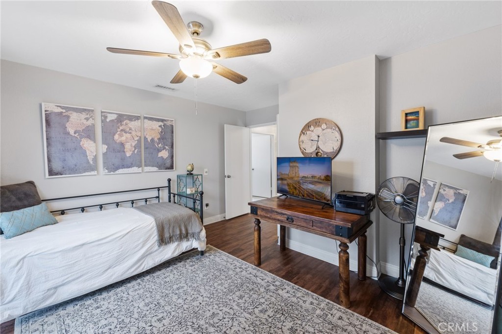 2565 Laramie Road Riverside, CA 92506 - Photo 31 of 46 a bedroom with a bed a clock on wall and a large window