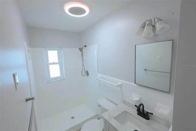 an empty room with a fan & a ceiling fan