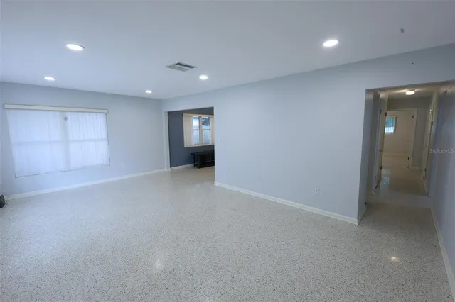 an empty room with wooden floor and ceiling fan