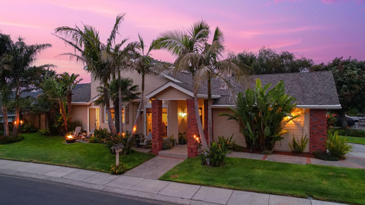 a front view of a house with a yard and potted plants